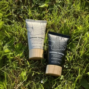 Daruma Tattoo aftercare cream with Centella Asiatica in black and ashen tubes on grass